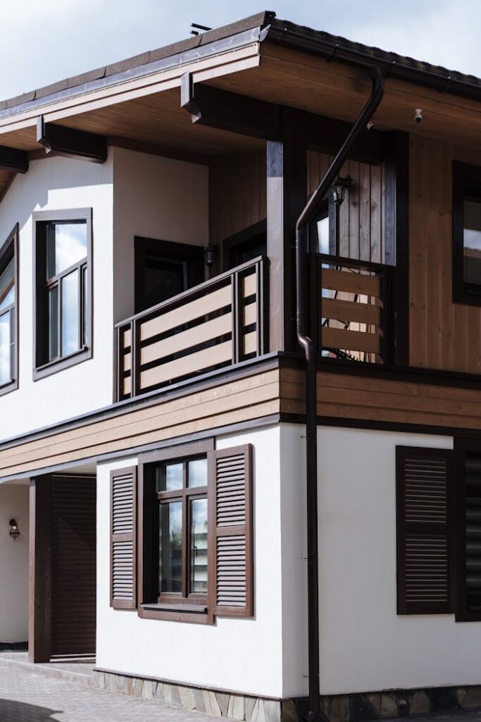 Contemporary suburban house exterior with wooden accents and shutters.